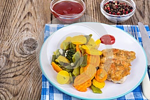 Chicken fillet grilled with vegetable mixt on wooden background