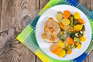 Chicken fillet grilled with vegetable mixt on wooden background