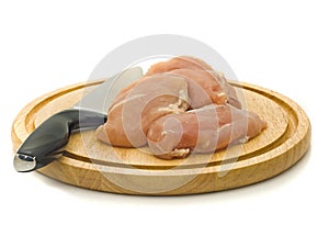Chicken fillet and knife on hardboard photo