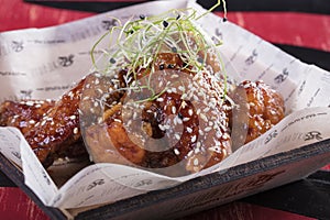 The chicken fried on a grill. Fried chicken wings with greens and grains. Very tasty and fragrant dish