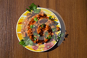 Chicken gizzard stew in plate on wooden table