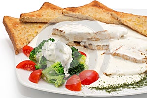 Chicken with gorgonzola, vegetables and bread on the plate