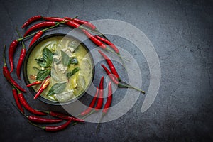 Chicken green curry Thai food on soup bowl with ingredient vegetable herbs and spices pepper chili dark background, Traditional