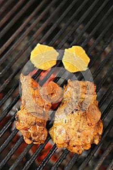 chicken with greens and vegetables roasting on a charcoal barbecue lit wood with fire for roasting chicken on the grill