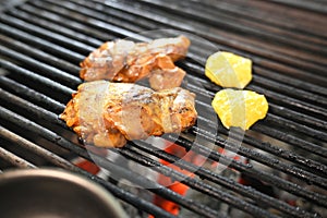 chicken with greens and vegetables roasting on a charcoal barbecue lit wood with fire for roasting chicken on the grill