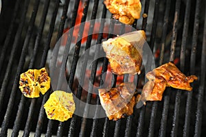 chicken with greens and vegetables roasting on a charcoal barbecue lit wood with fire for roasting chicken on the grill