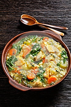 Chicken kale veggies soup in a bowl