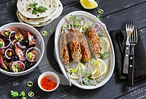 Chicken kebab, salad with tomatoes, onions and olives, homemade tortilla is a healthy and delicious meal