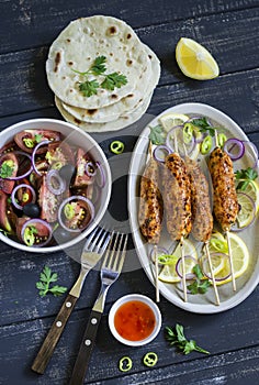 Chicken kebab, salad with tomatoes, onions and olives, homemade tortilla is a healthy and delicious meal