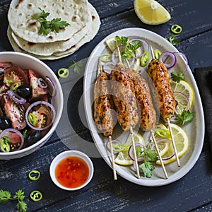 Chicken kebab, salad with tomatoes, onions and olives, homemade tortilla is a healthy and delicious meal