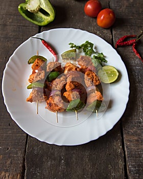 Chicken kebabs or doners grilled with saute vegetables in a white plate.