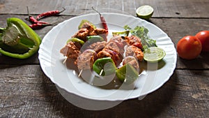 Chicken kebabs or doners grilled with saute vegetables in a white plate.