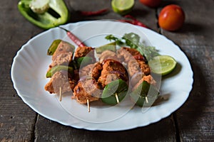 Chicken kebabs or doners grilled with saute vegetables in a white plate.