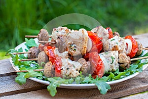 Chicken kebabs on plate with arugula