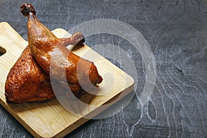 Chicken legs cooked on a grill on a cutting board on a black background. Copy space for text