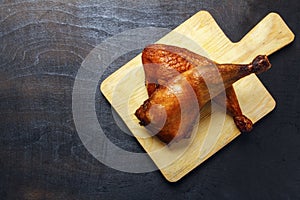 Chicken legs, cooked on a grill on a wooden cutting board. Top view. Copy space