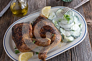 Chicken legs with cucumber salad on a plate