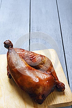 Chicken legs of poultry, grilled on a cutting board on a wooden table. Copy space. Vertical