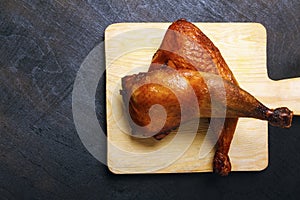 Chicken legs, roasted on a grilled on a black wooden table. Top view. Copy space