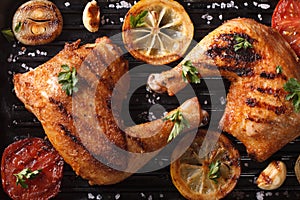 Chicken legs and vegetables on grill macro. Top view horizontal