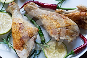 Chicken legs on white plate with rosemay and lime