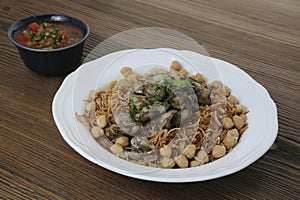 Chicken liver noodles with chickpea, tomato and chilli sauce served in dish isolated on table side view of arabic food