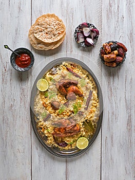 Chicken Mandi with dates on a wooden table. Arabic cuisine photo