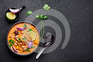 A Chicken Massaman Curry in black bowl at dark slate background. Massaman Curry is Thai Cuisine dish Thai Food photo
