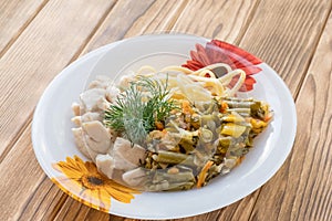 Chicken meat in a plate with fried vegetables and pasta
