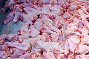 chicken meat products. woman hand using stainless steel handle choosing chicken meat on cutting in supermarket.