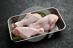 Chicken meat. Raw fresh chicken drumsticks on black slate stone background.