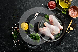 Chicken meat. Raw fresh chicken drumsticks on black slate stone background.