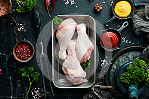 Chicken meat. Raw fresh chicken drumsticks on black slate stone background.