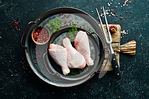 Chicken meat. Raw fresh chicken drumsticks on black slate stone background.