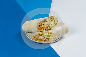 Chicken meat Shawarma roll on light, dark blue and white abstract background. Street food grilled donner sandwich
