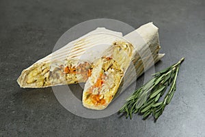 Chicken meat shawarma served with rosemary on dark background