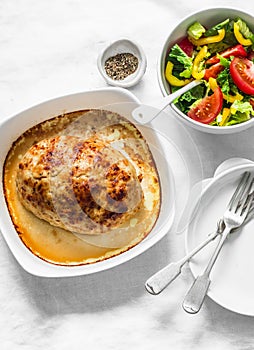 Chicken meatloaf and fresh tomato yellow bell pepper vegetables salad on a light background, top view. Healthy balanced diet food