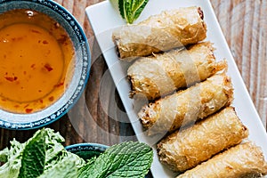 Chicken spring rolls with spicy sauce and fresh mint leaves photo
