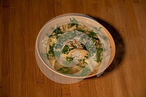 Chicken Noodle Soup. Chicken and noodle soup on an orange tablecloth in an orange plate. Food photography. Hot dish