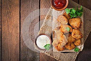 Chicken nuggets and sauce, top view.