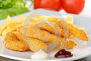 Chicken nuggets/sticky fingers with french fries photo