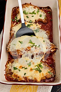 Chicken parmigiana served on top of spaghetti with marinara sauce.