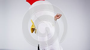 Chicken, party and costume with a man dancing in studio on a gray background for fun as a comic alone. Music, dance and