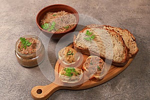 Chicken pate with homemade whole grain bread and herbs on a dark table, the concept of a healthy lifestyle and natural nutrition.