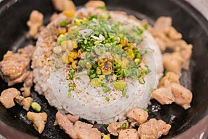 Chicken pepper with rice on hot plate on top with corn