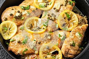 Chicken Piccata with capers, white wine sauce in iron cast pan. Italian food
