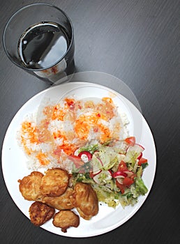 Chicken on a plate with rice and salad