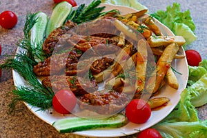 Chicken ribs in honey sauce with french fries and vegetables