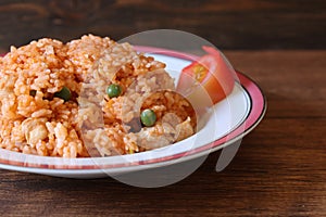 Chicken rice on the dish isolated on a wooden table