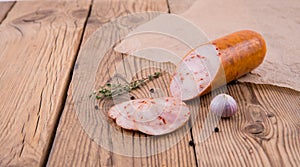 Chicken roll with paprika lies on an old wooden table with a sprig of thyme and garlic. background for design